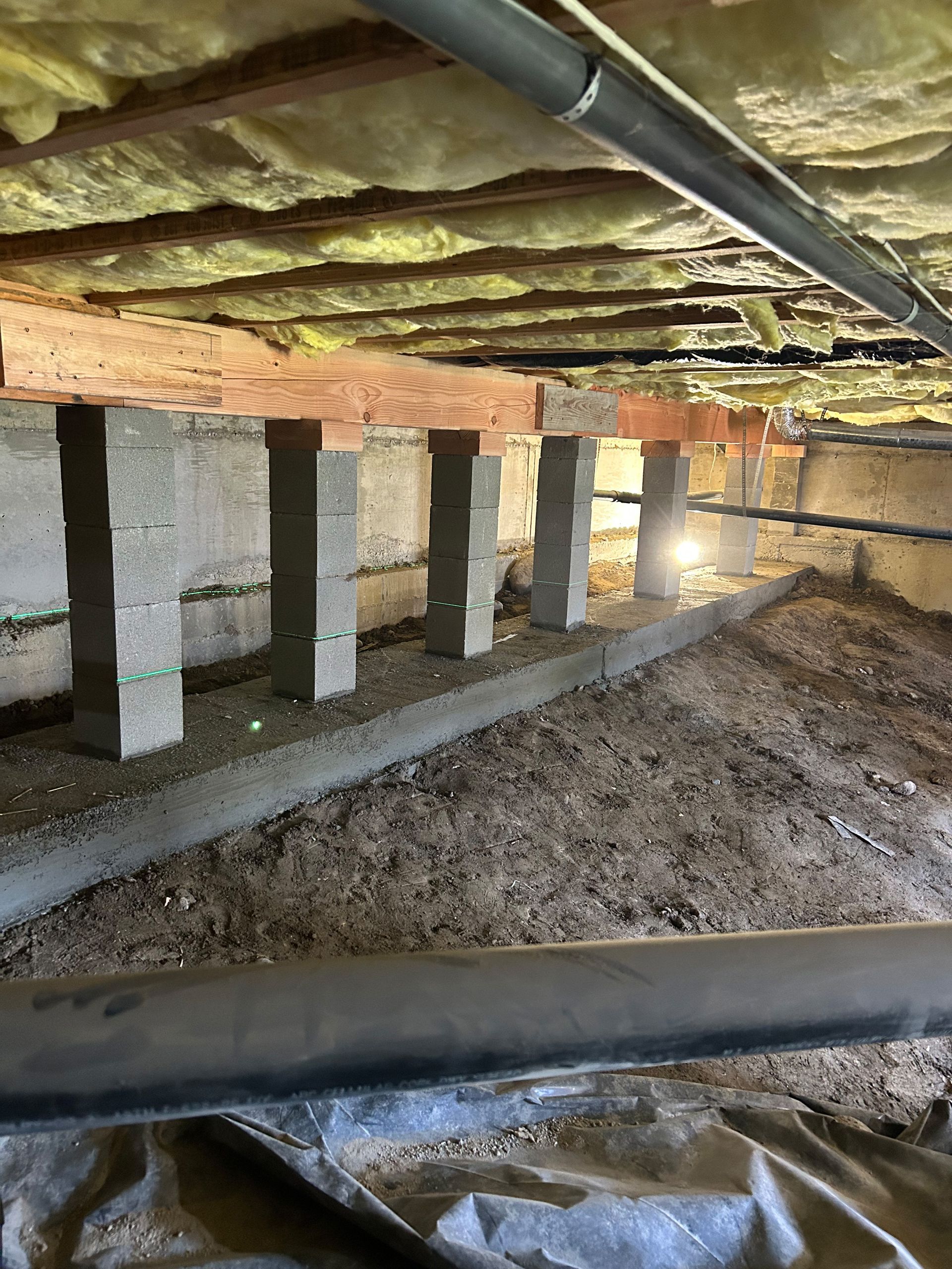 A basement with a lot of concrete blocks and insulation.