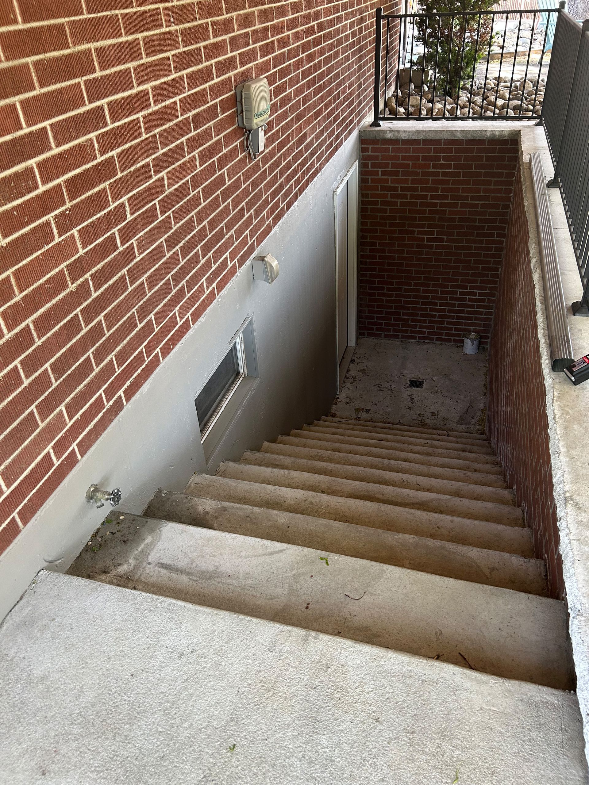 A set of stairs leading up to a basement under a brick building.