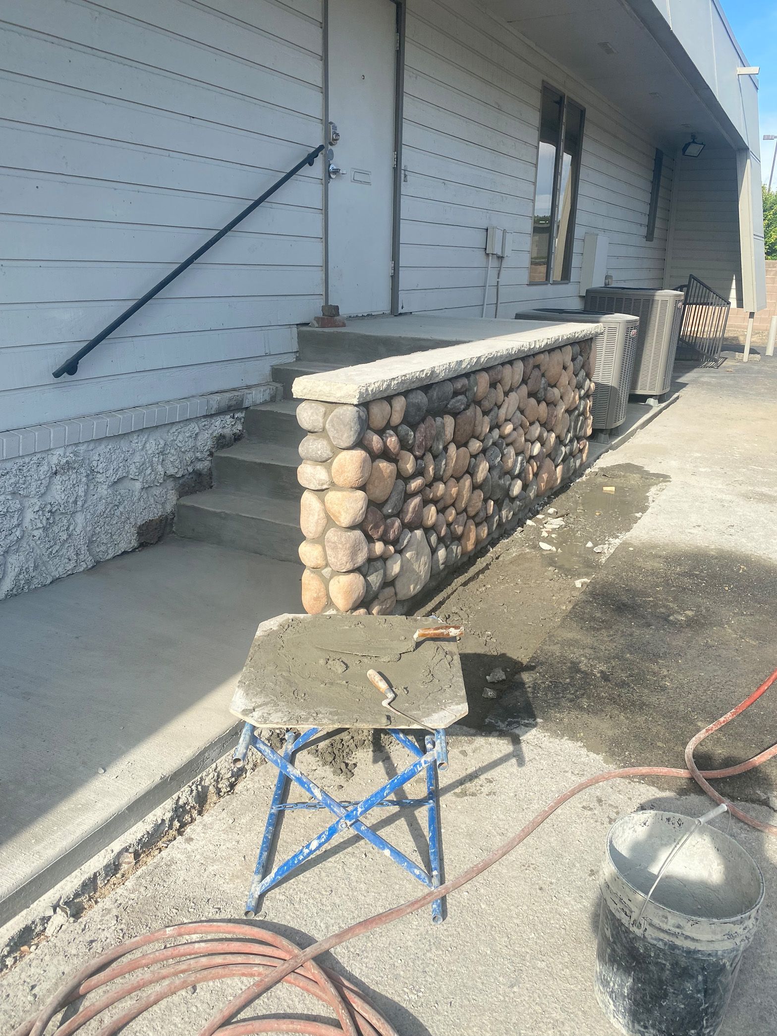 A stone wall is being built in front of a building.