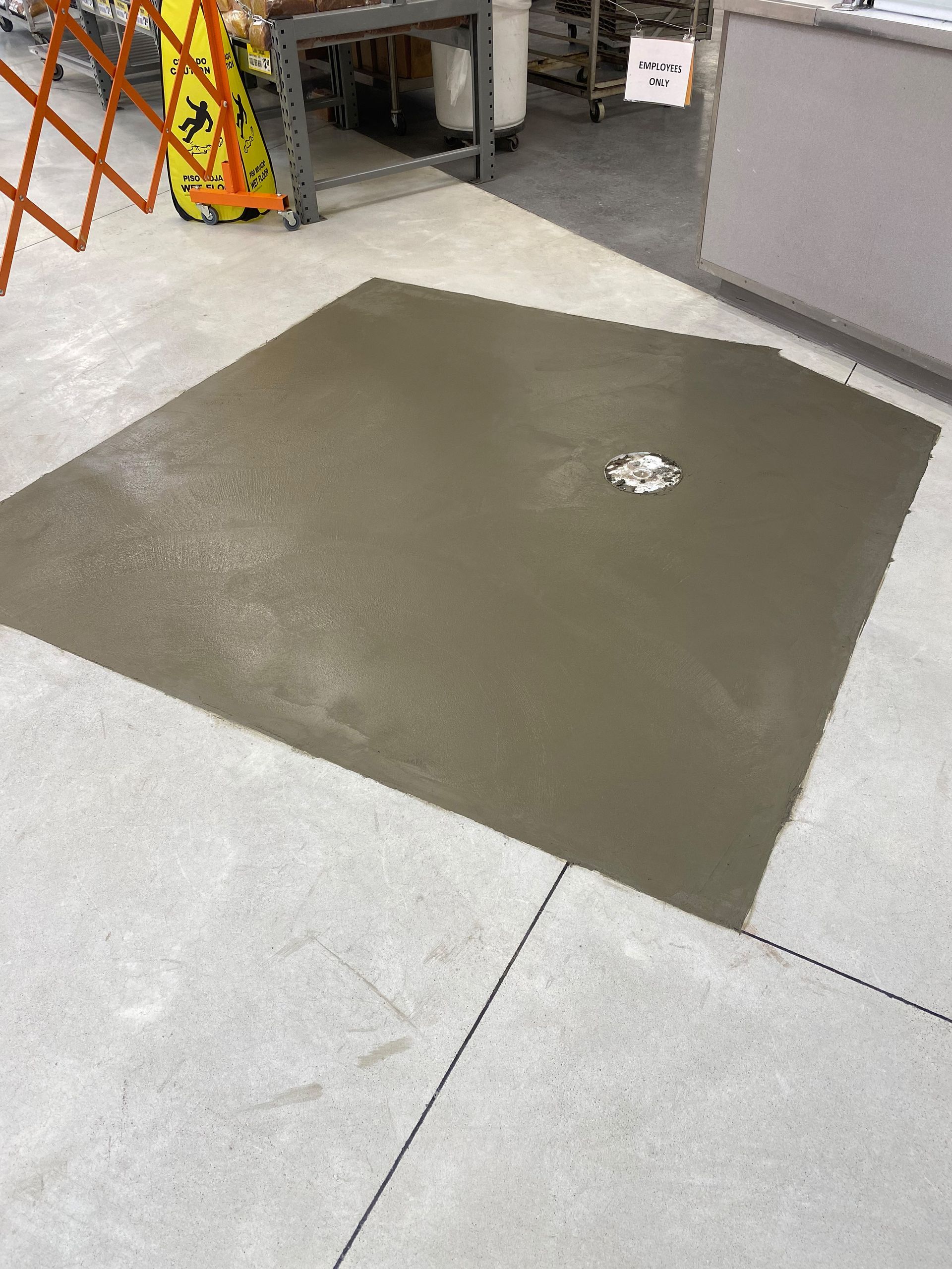 A large square of concrete is sitting on a concrete floor.