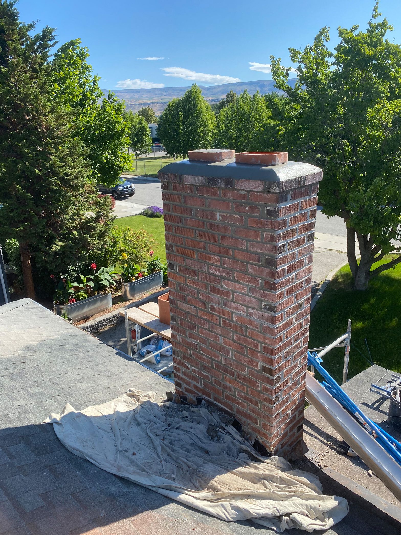 A brick chimney is sitting on top of a roof.