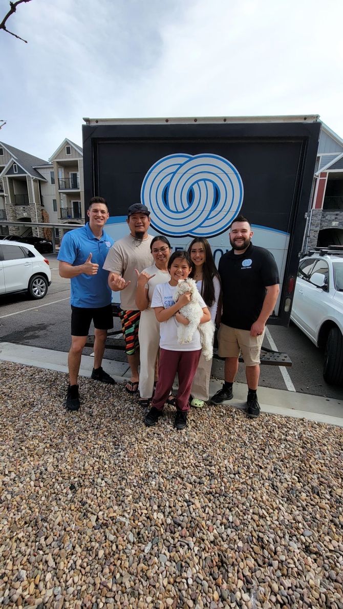 A group of people are posing for a picture in front of a truck.