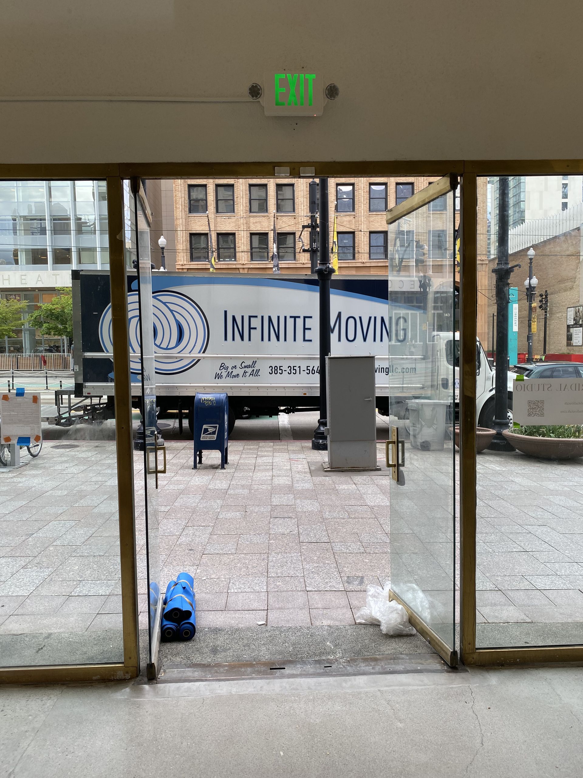 An infinite moving truck is parked in front of a building