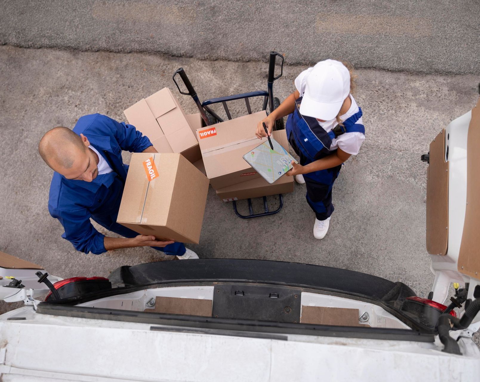 a man and a woman are loading boxes into a truck .