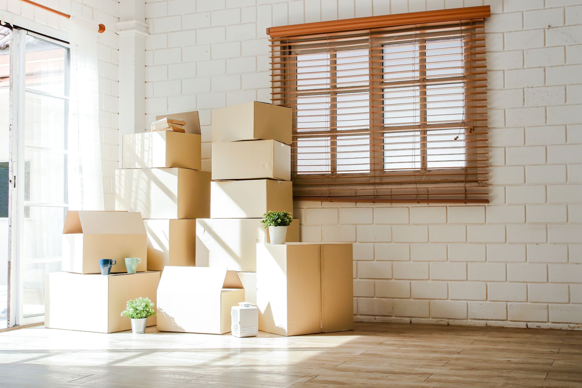 two men are packing boxes in a living room .