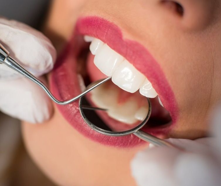 A Woman Is Getting Her Teeth Examined By A Dentist — Mittagong Dental Care In Mittagong, NSW