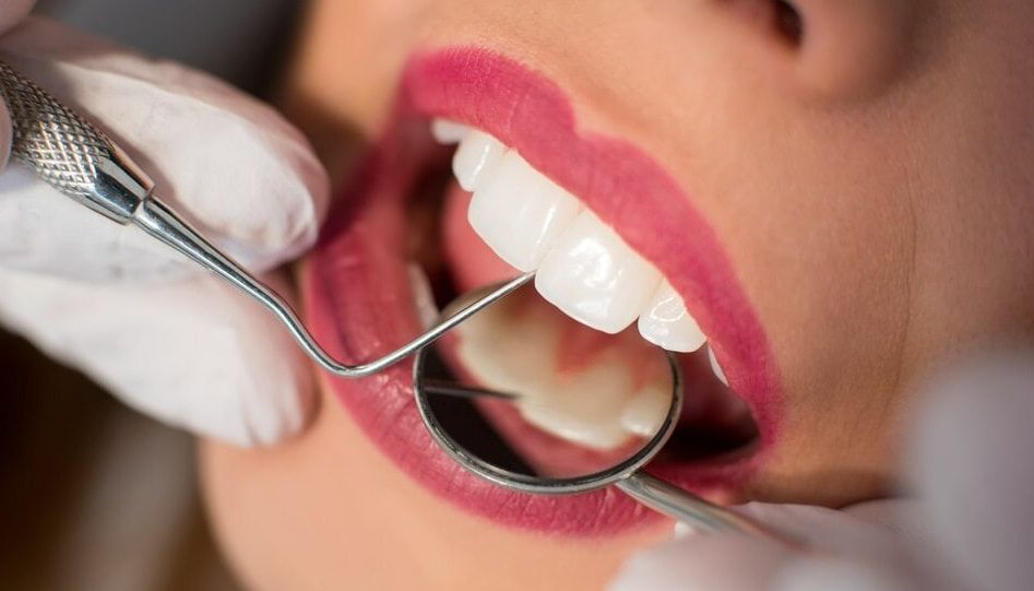 A Woman Is Getting Her Teeth Examined By A Dentist — Mittagong Dental Care In Mittagong, NSW