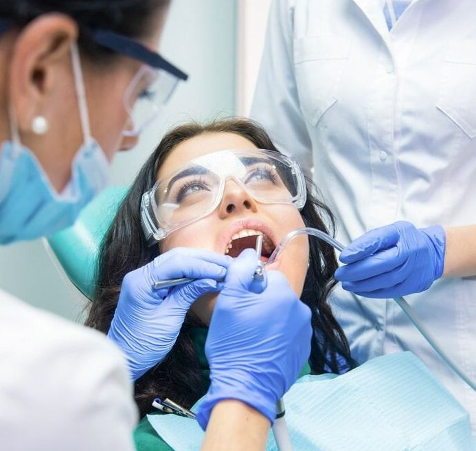 A Woman Is Getting Her Teeth Examined By A Dentist — Mittagong Dental Care In Mittagong, NSW