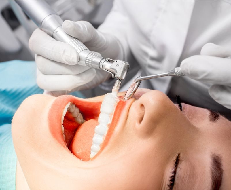 A Woman Is Getting Her Teeth Cleaned By A Dentist — Mittagong Dental Care In Mittagong, NSW