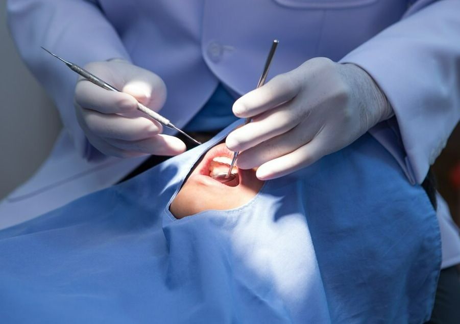 A Dentist Is Examining A Patient's Teeth In A Dental Office — Mittagong Dental Care In Mittagong, NSW