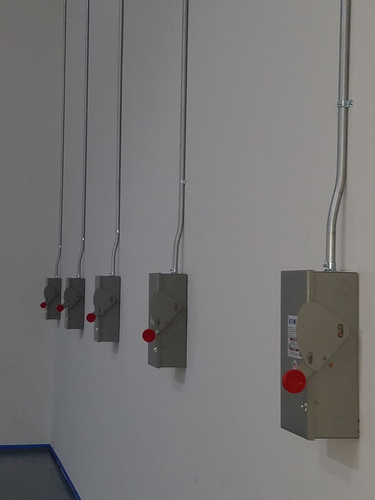 A row of electrical switches are lined up on a wall.