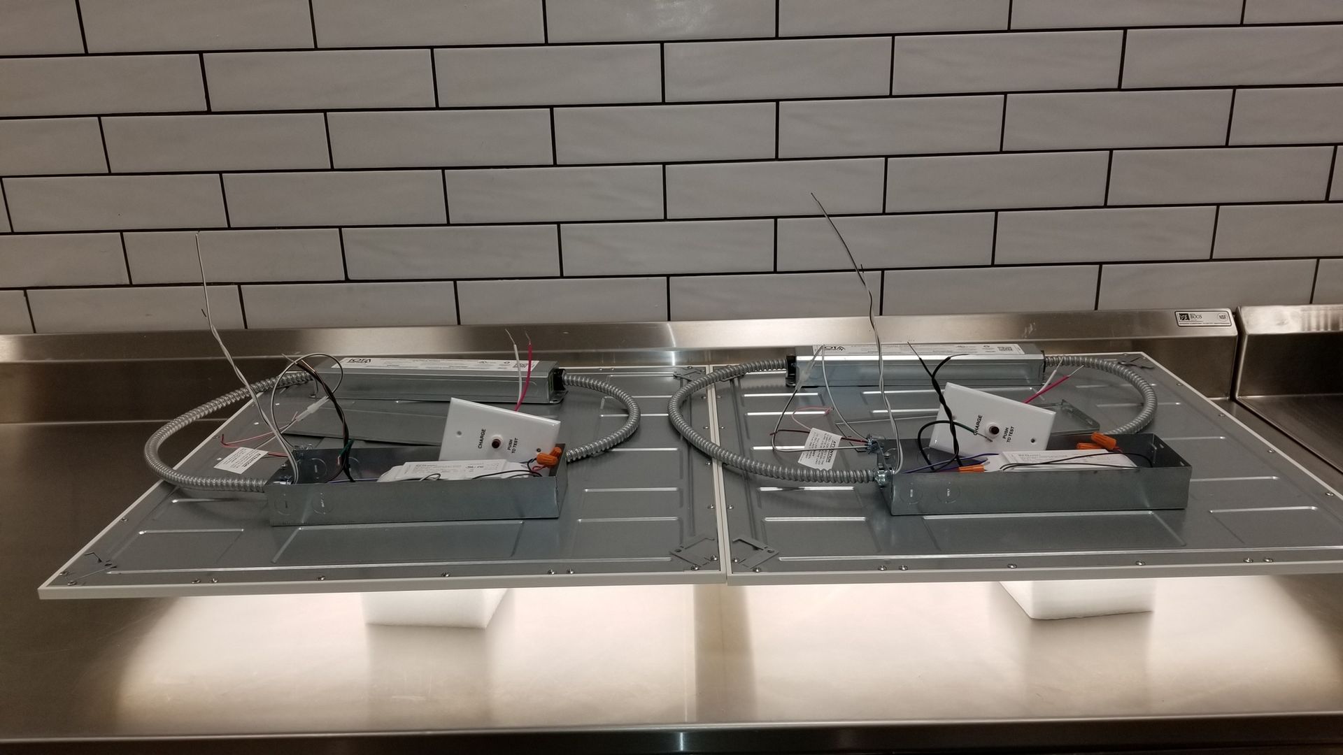 Two lights are sitting on top of a stainless steel counter.
