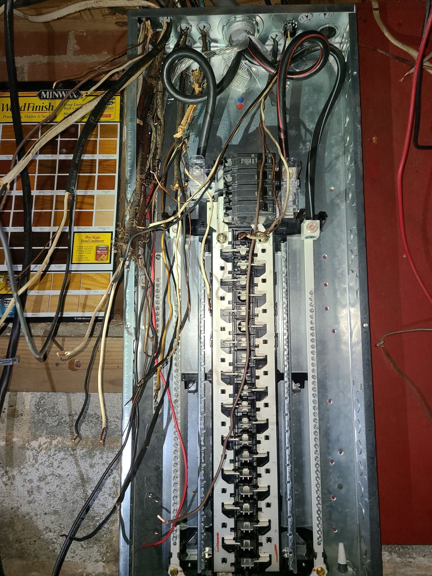 A very messy electrical panel with a lot of wires coming out of it.