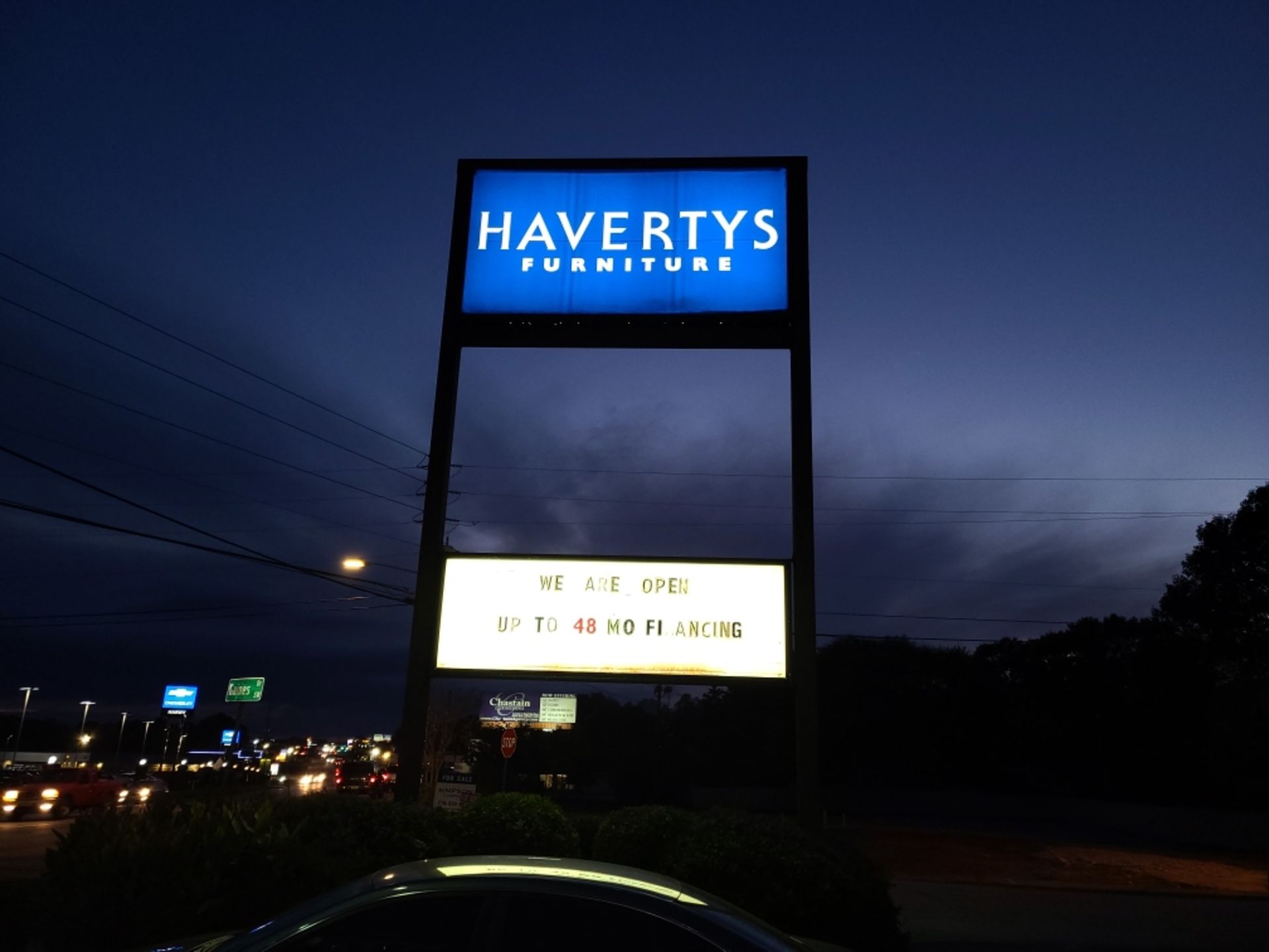 A sign for havertys furniture is lit up at night