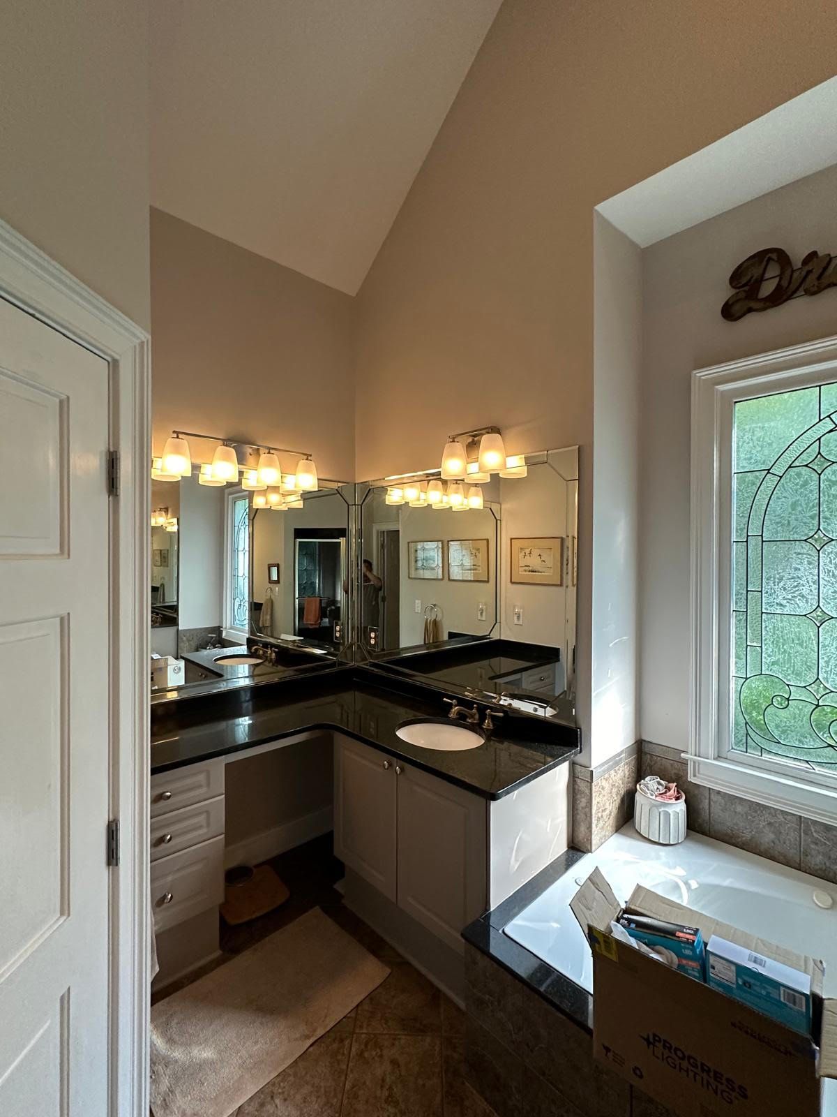 A bathroom with two sinks , a tub and a window.