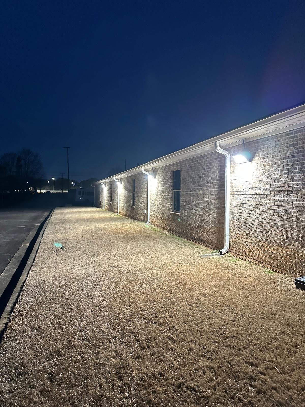 A row of brick buildings are lit up at night.
