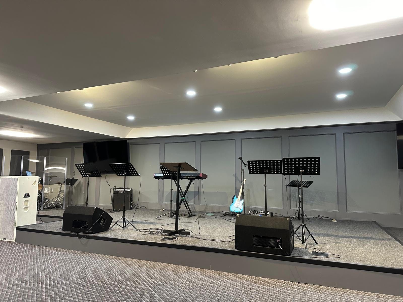 A large room with a stage and a lot of musical instruments on it.