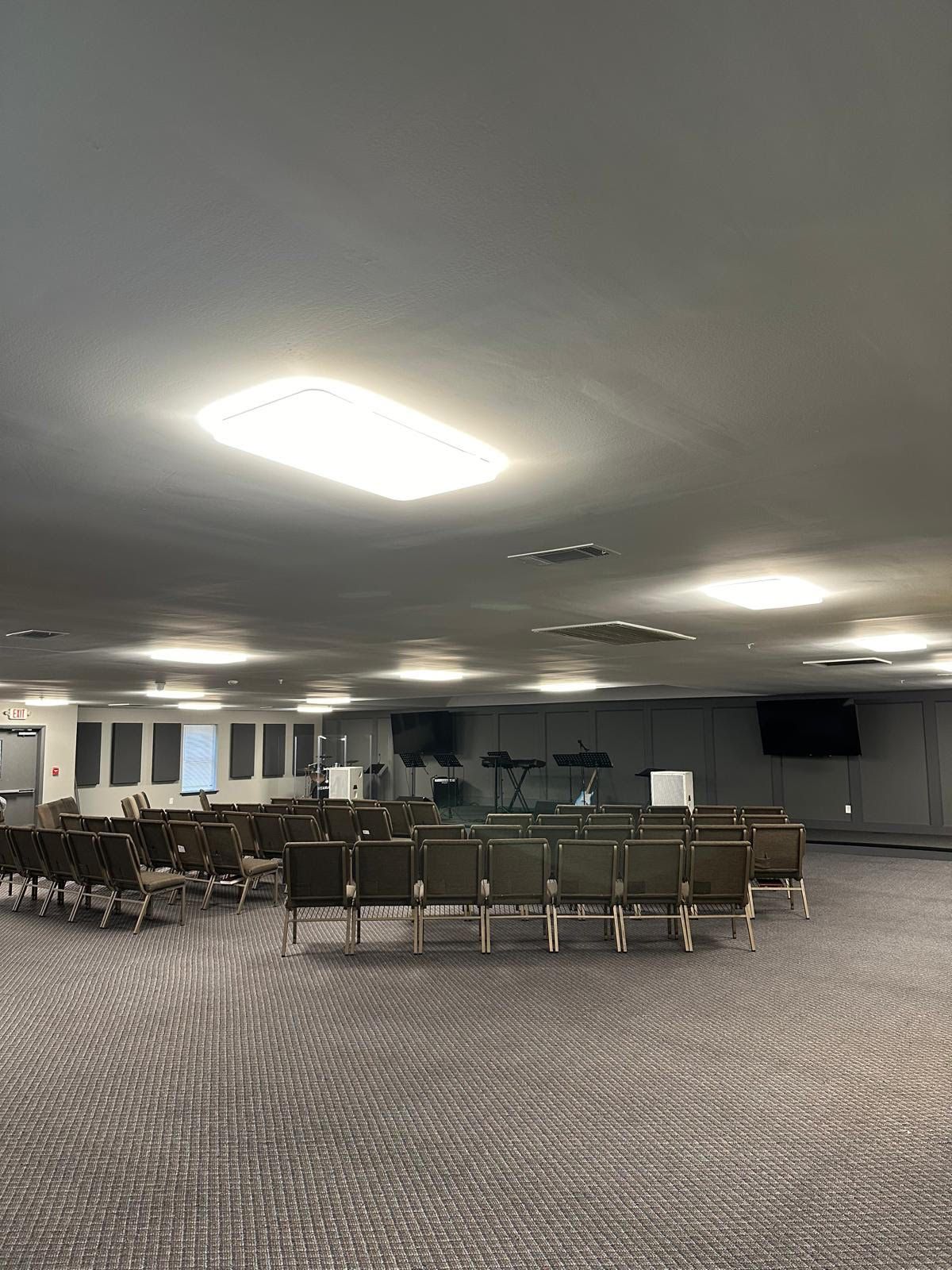 A large room with rows of chairs and a ceiling light.