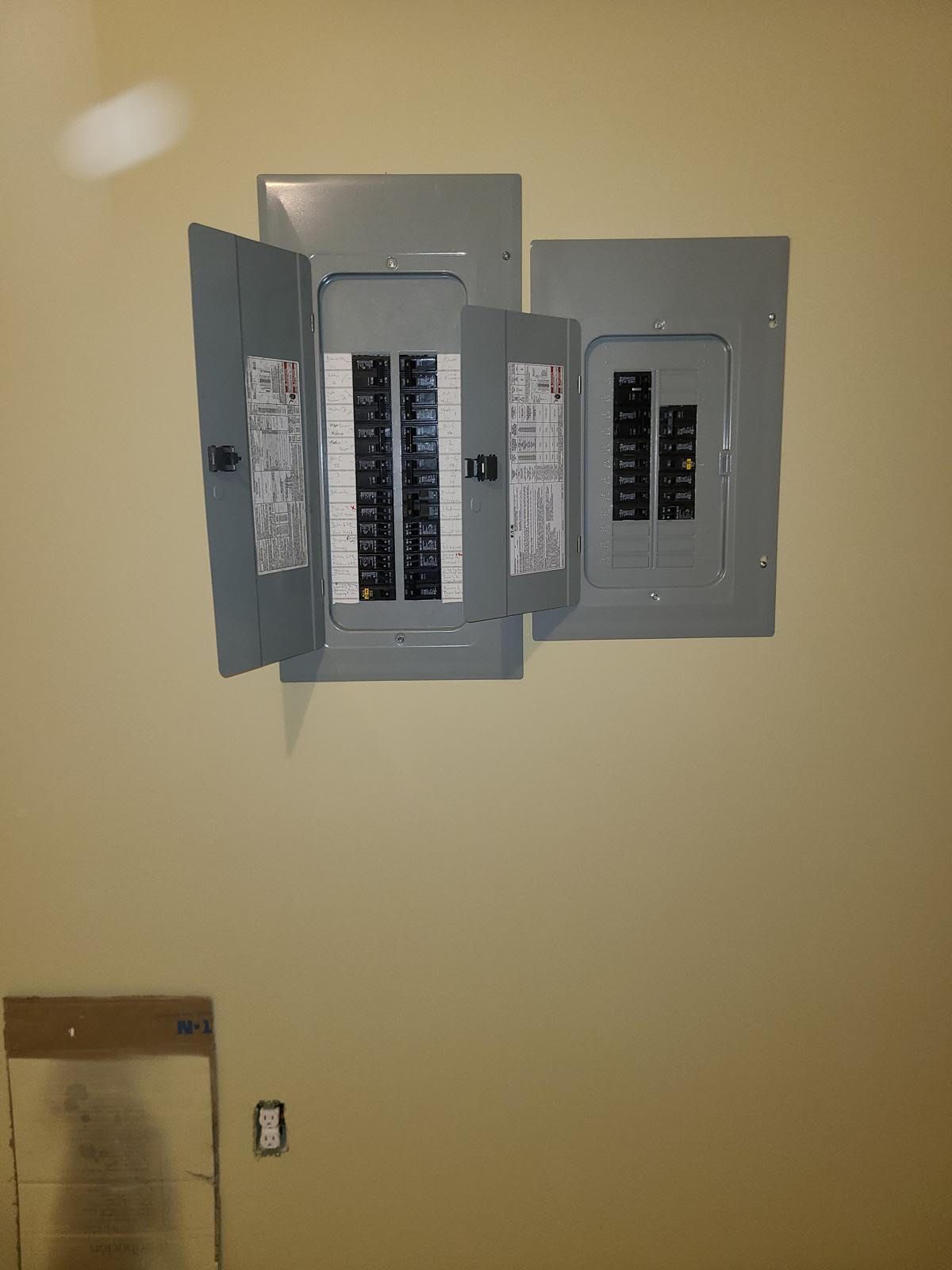 A electrical box is hanging on a wall in a room.