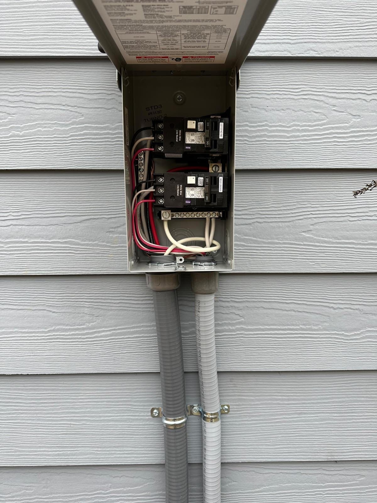 A close up of an electrical box on the side of a house.