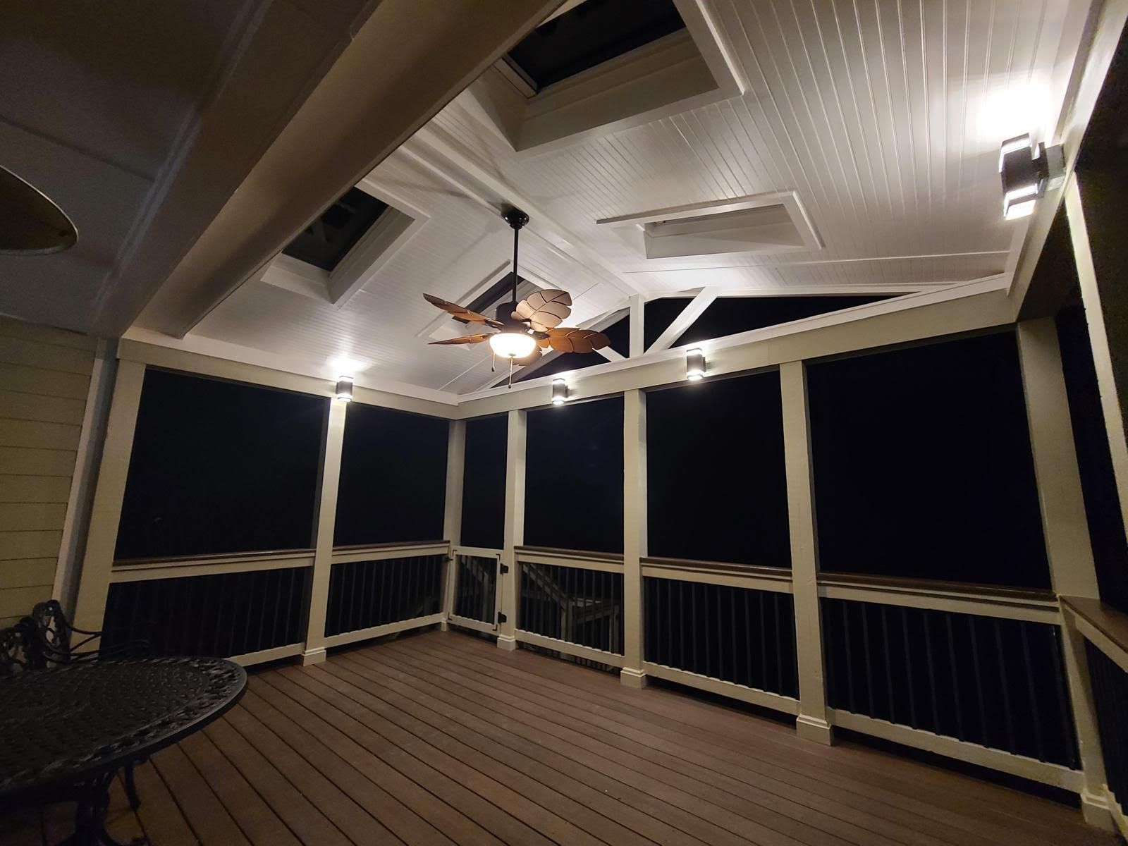 A ceiling fan is hanging from the ceiling of a porch