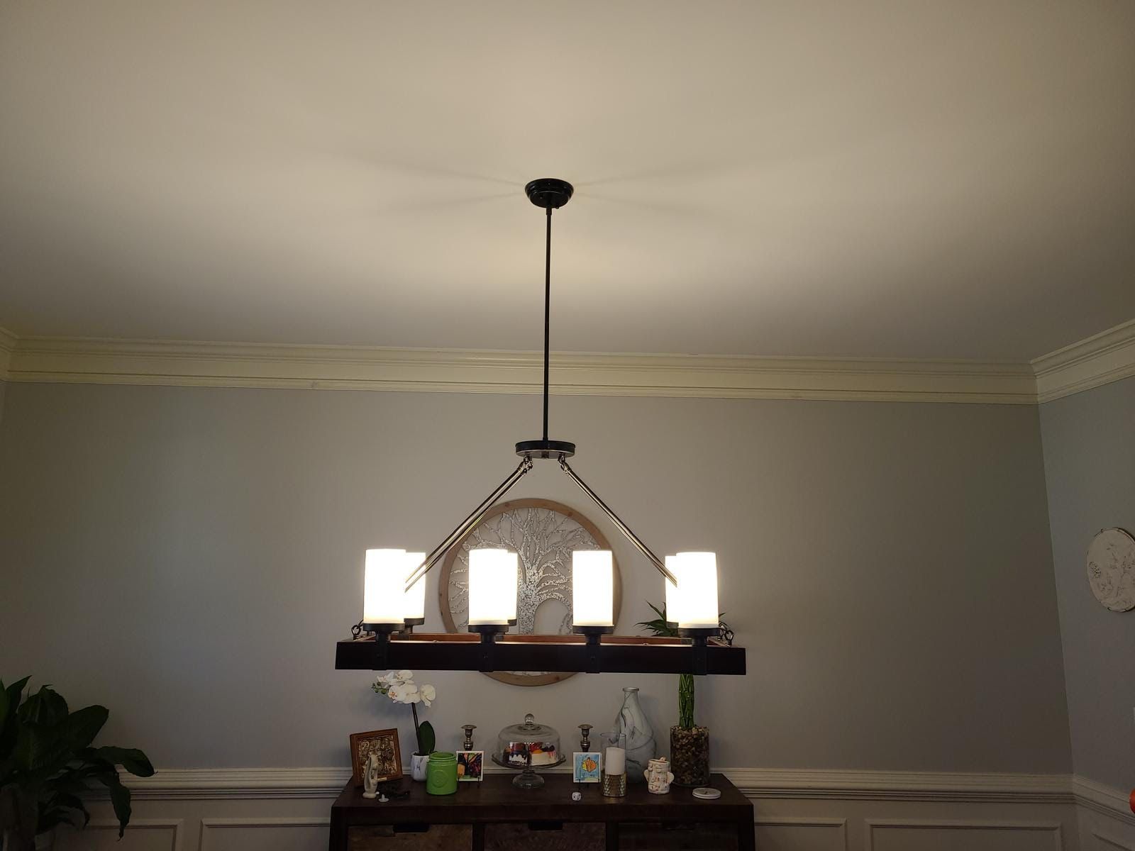 A dining room with a chandelier hanging from the ceiling