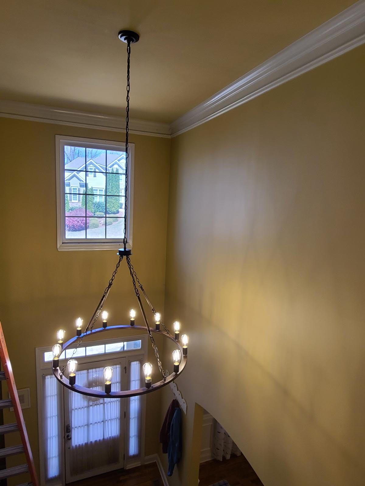 A chandelier is hanging from the ceiling in a room with yellow walls.