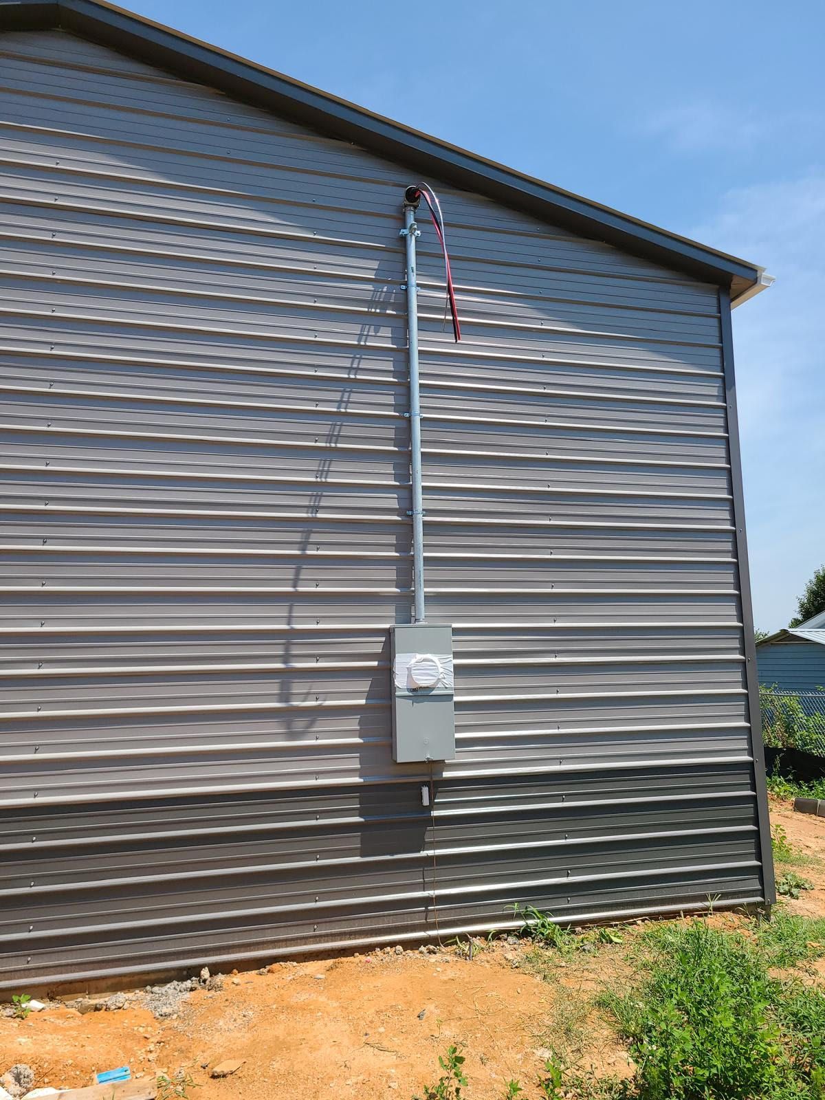 A metal building with a electrical box on the side of it.