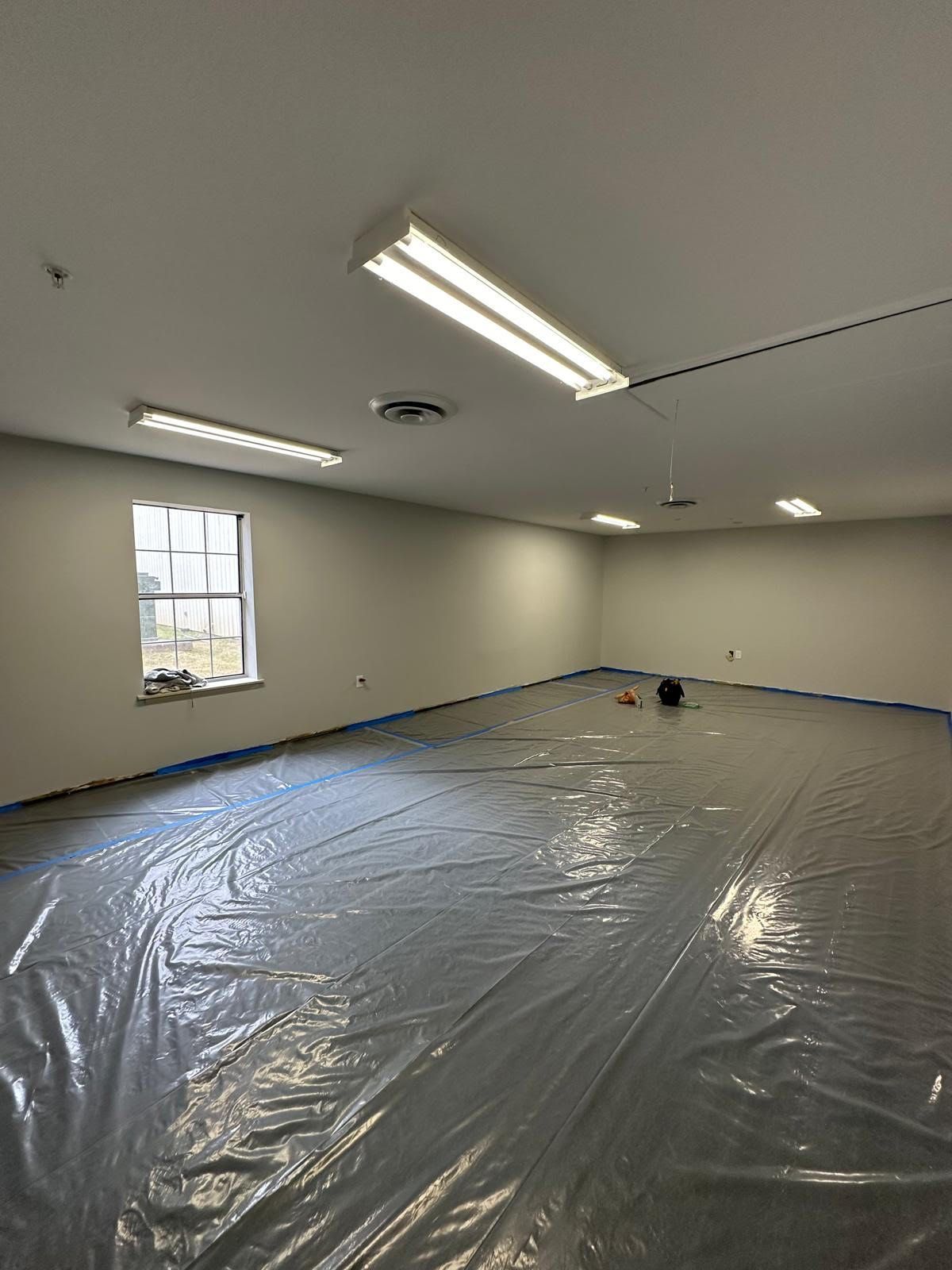 A large room with a lot of plastic on the floor and a window.