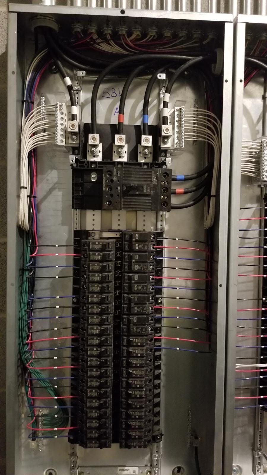 A close up of a electrical panel with a lot of wires coming out of it.