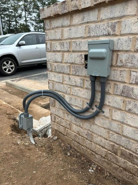 A brick wall with a box on it and a car parked in the background.