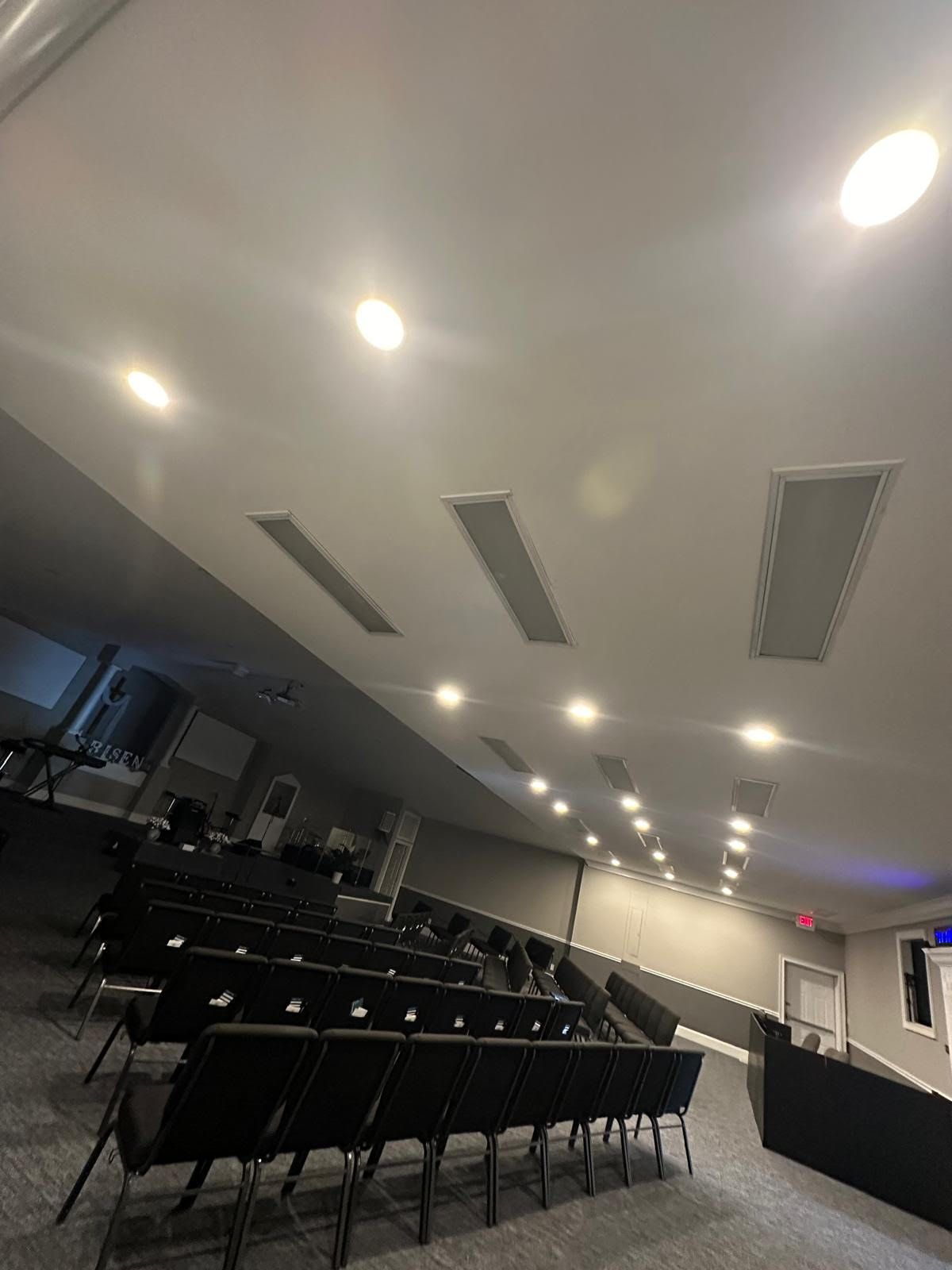 A large auditorium with rows of chairs and a projector screen.