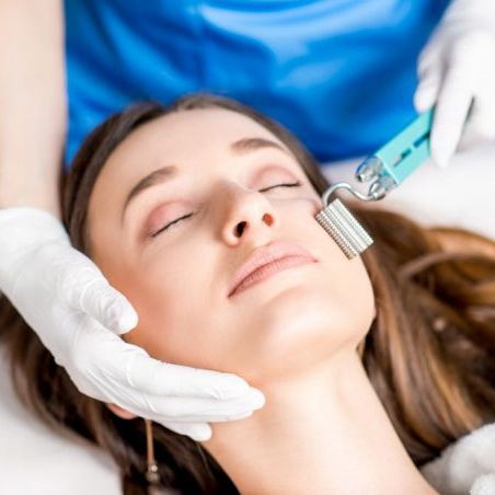 Uma mulher está fazendo um tratamento facial com um rolo no rosto.