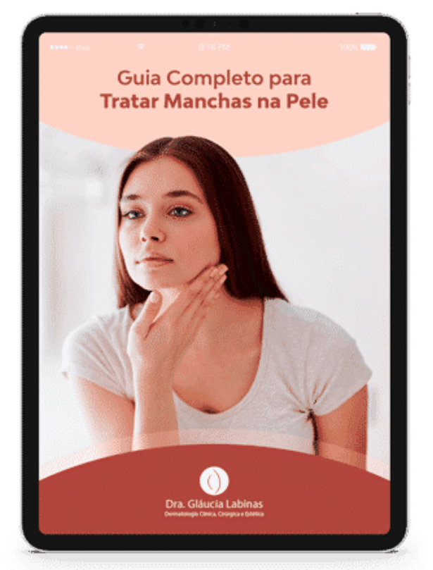 Uma mulher está olhando para seu rosto em um tablet que diz guia completo para tratar manchas na pele