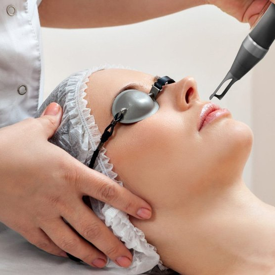 Uma mulher está recebendo um tratamento a laser no rosto