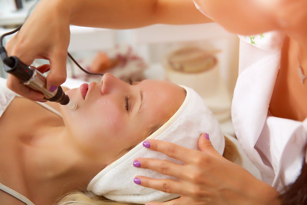 Uma mulher está fazendo tratamento facial em um salão de beleza.