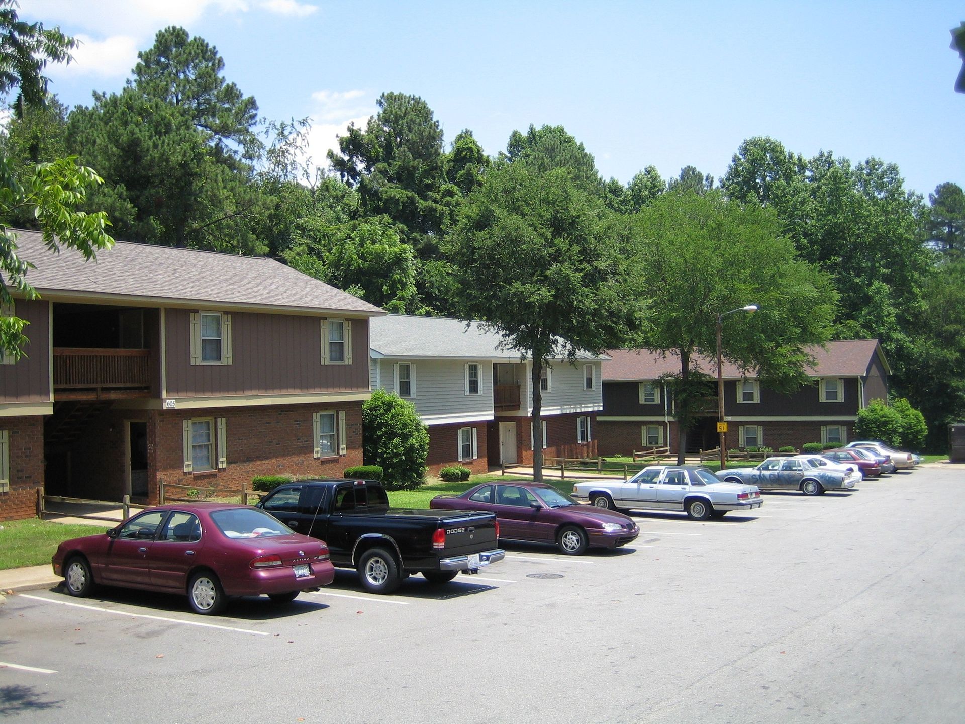 A row of cars are parked in front of a brick building