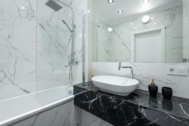A bathroom with a sink , bathtub , shower and mirror.