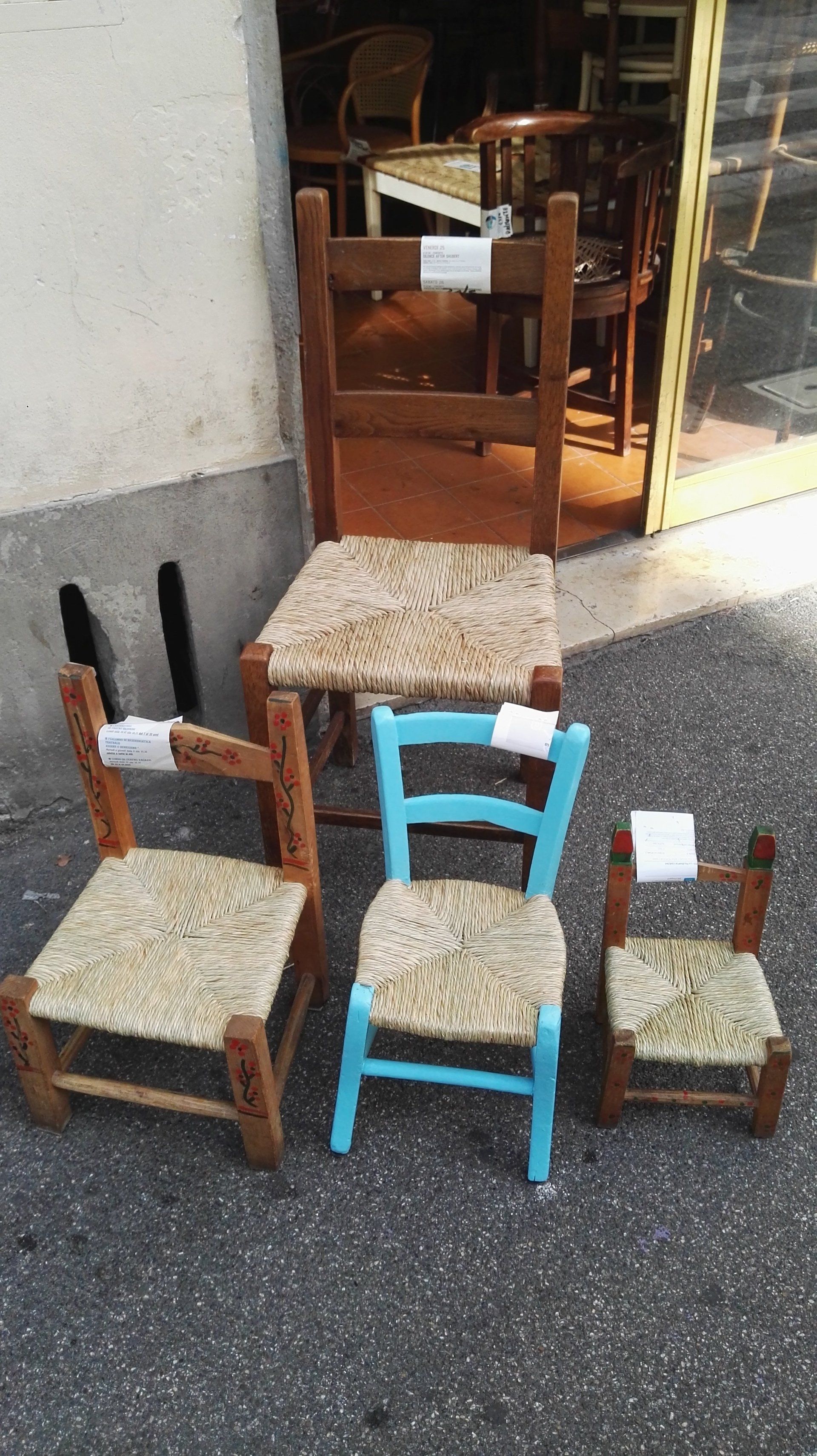 vista di sedie capovolte con sedute di paglia intrecciata a mano