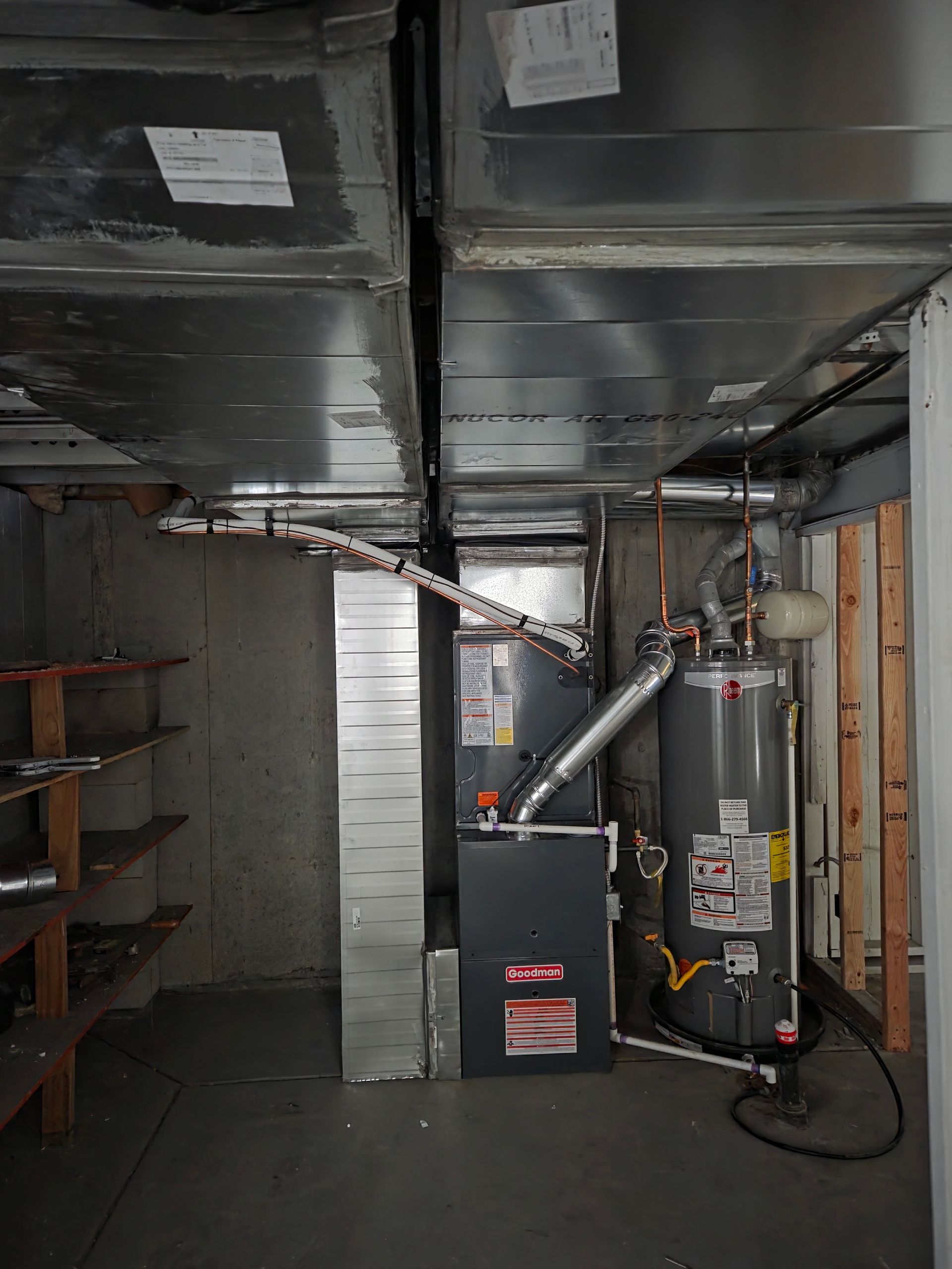 HVAC system in basement with ductwork, furnace, water heater, and shelving unit.