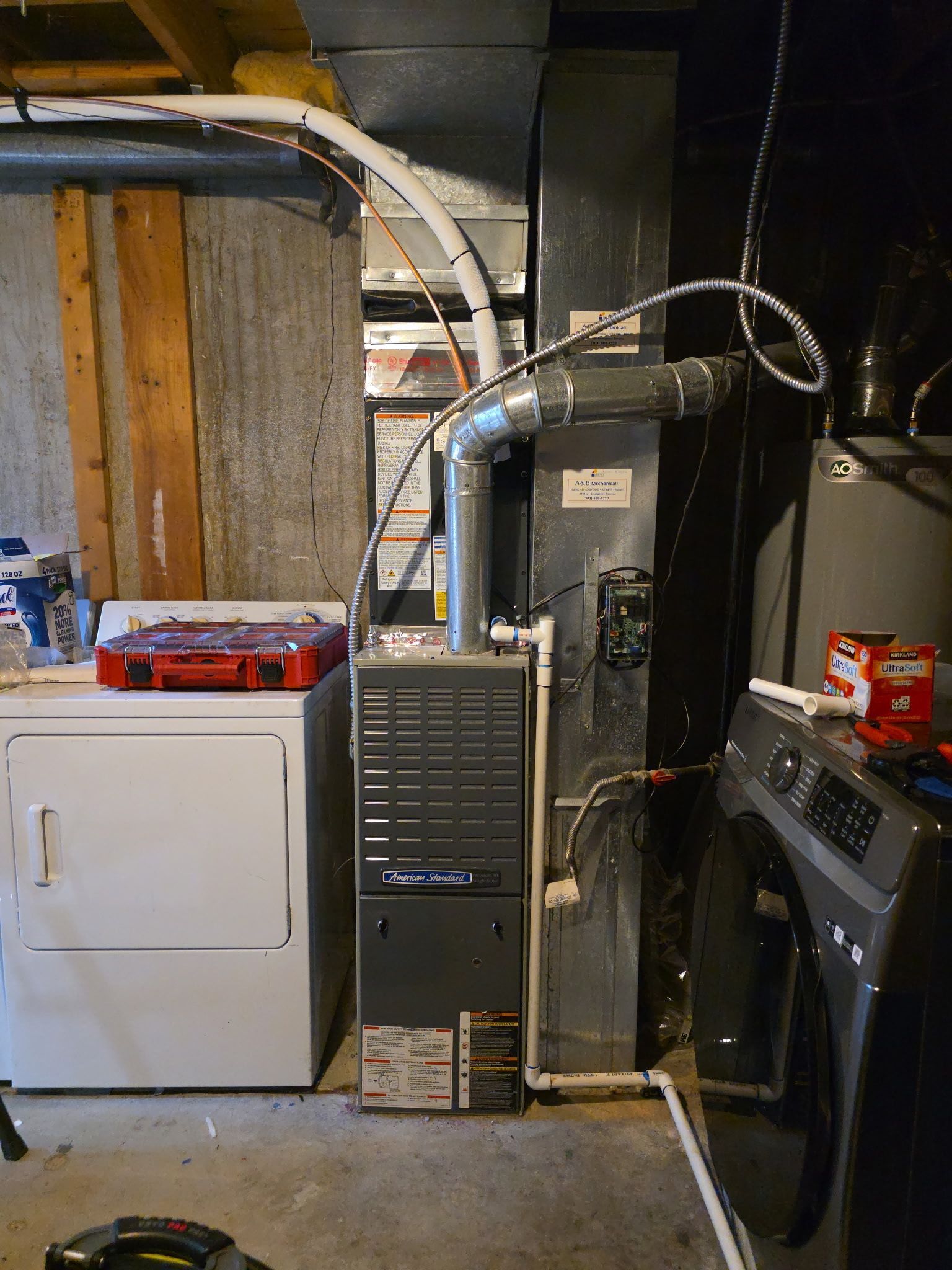 Furnace and dryer in a basement. Ductwork and wiring visible. Gray, white, and red objects are present.