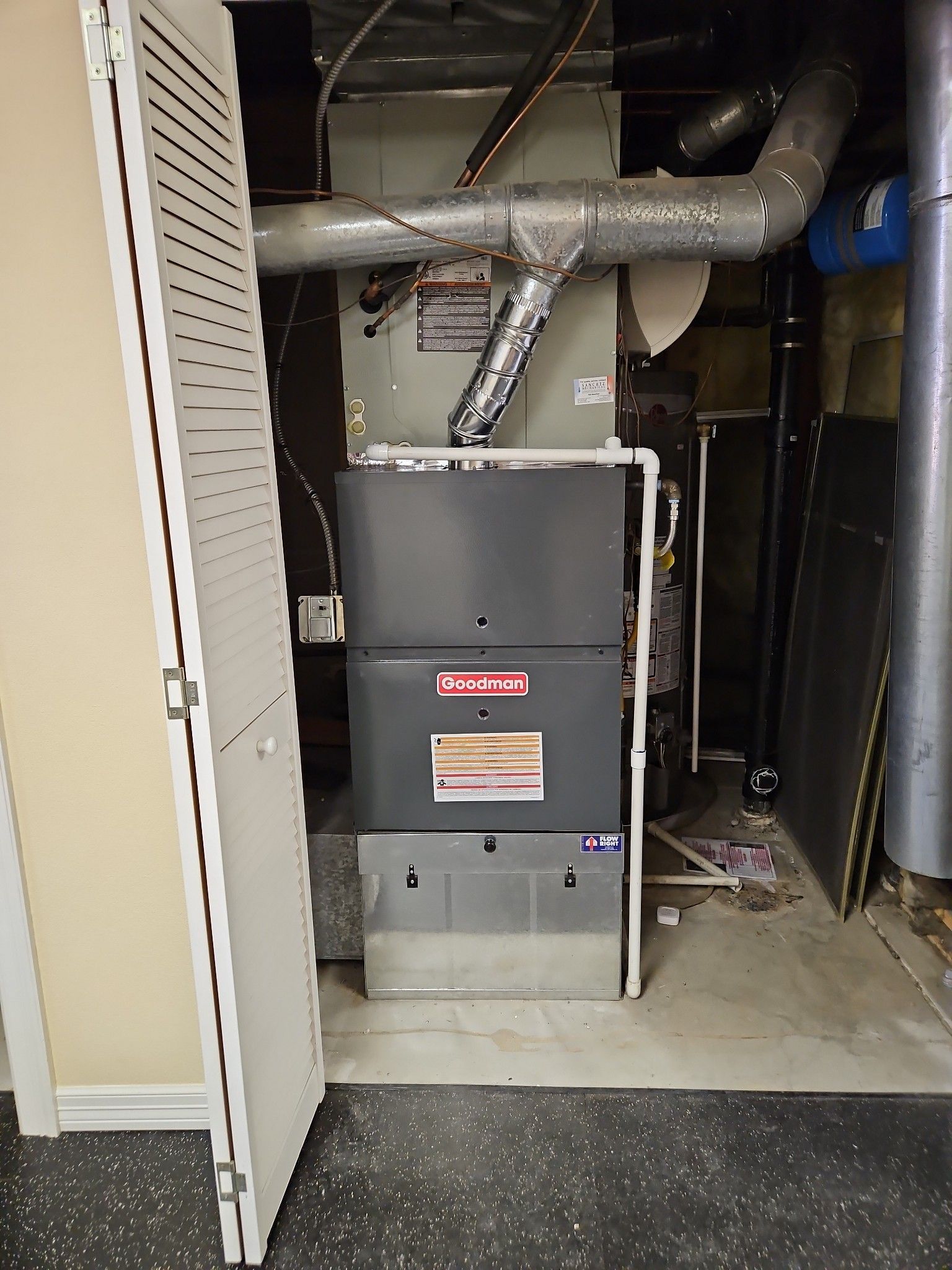 Furnace unit in a utility room with attached ductwork and vent.