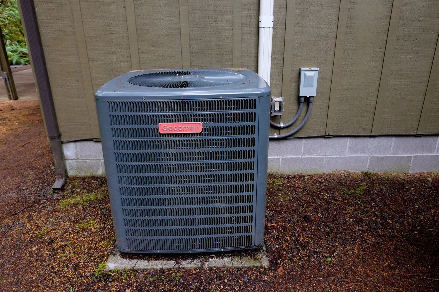 Air conditioning unit outside a building, gray with a red logo.
