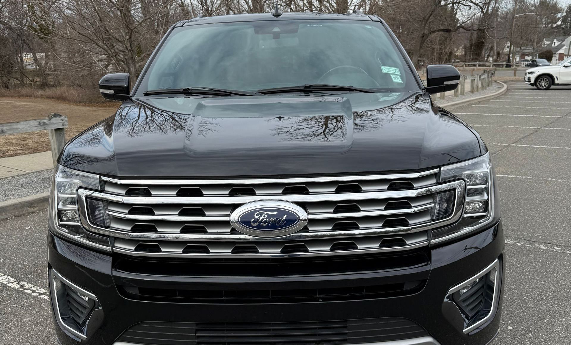 A black ford expedition is parked in a parking lot.