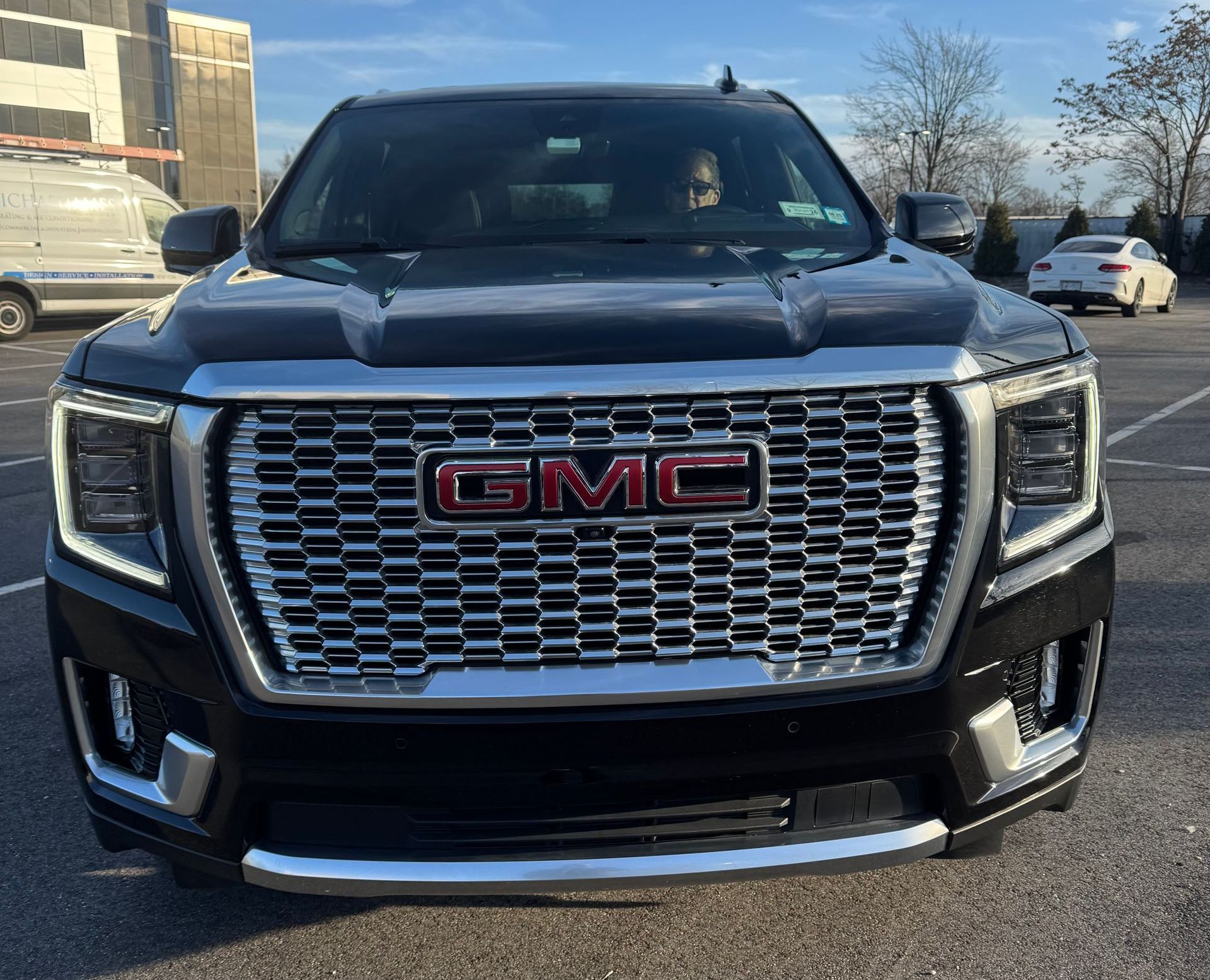 A black gmc truck is parked in a parking lot.