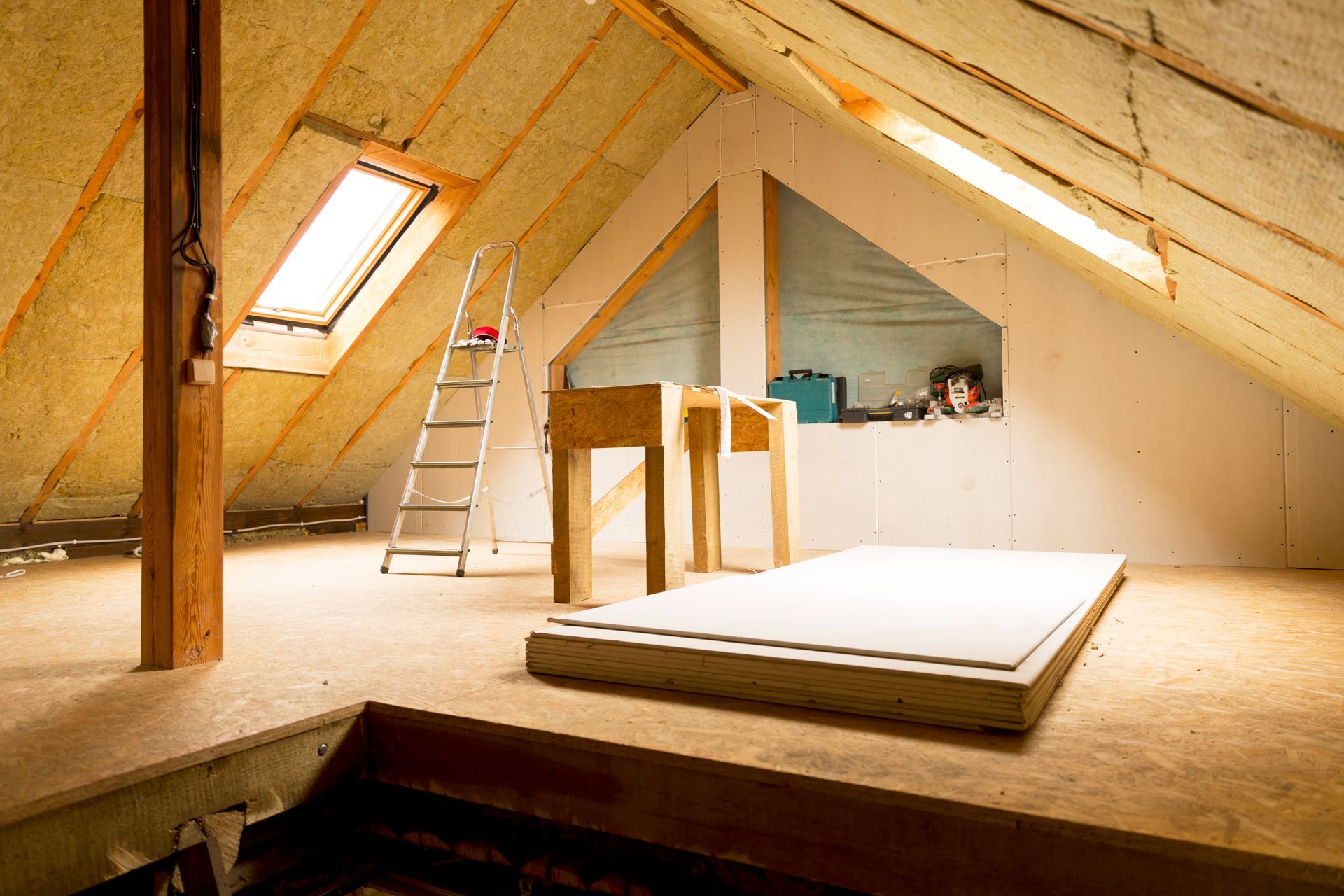An attic with a ladder and a table in it.