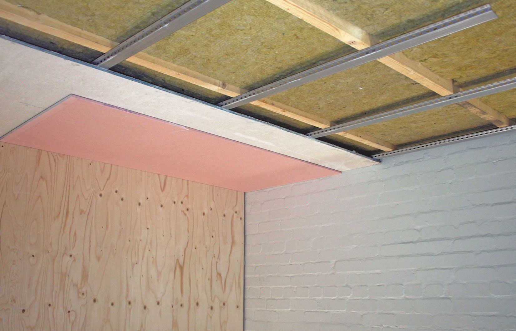 It shows the inside of a brick wall with a living room in the background.