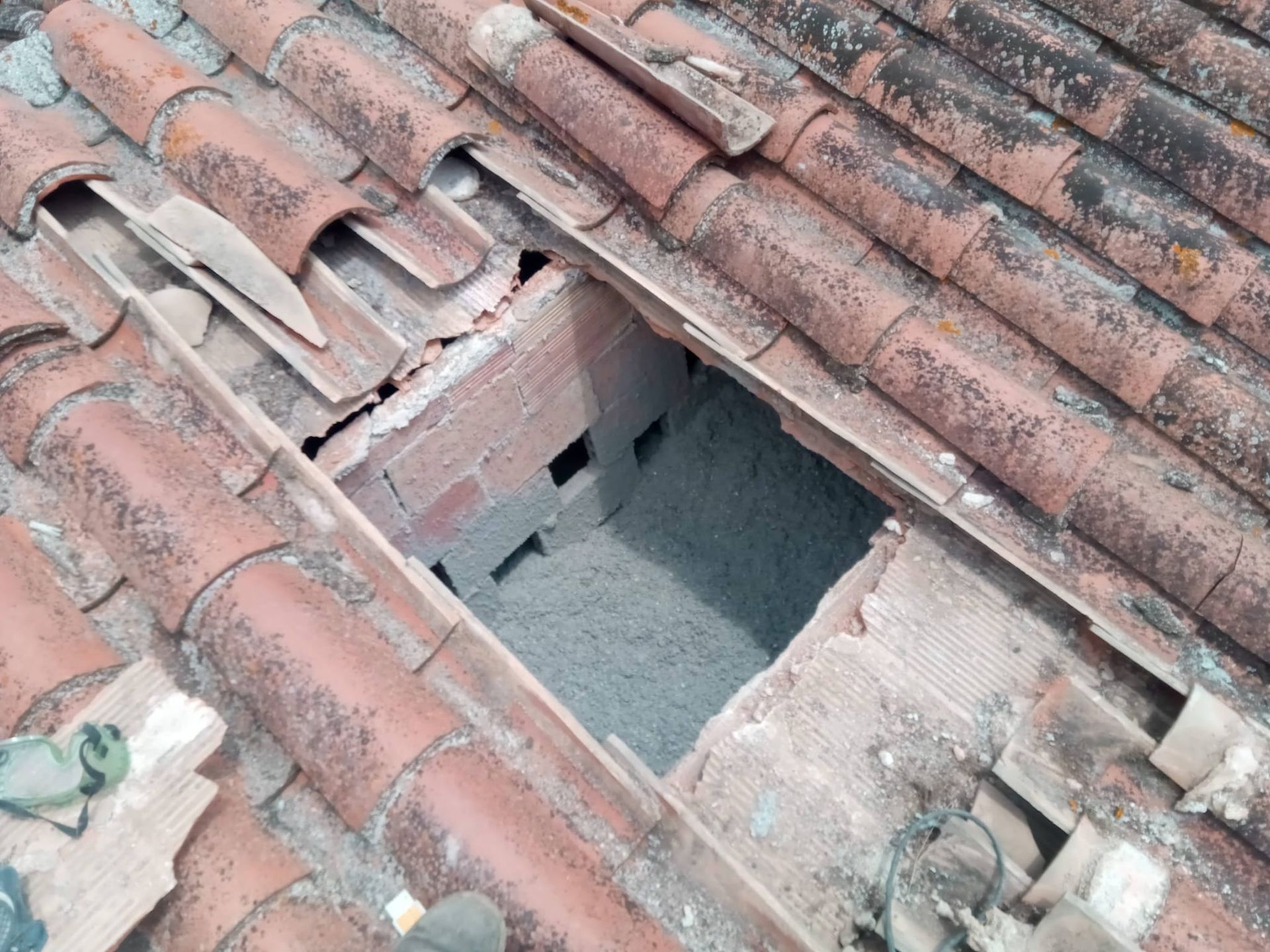 Un hombre que lleva un casco está trabajando en una pared de ladrillos.