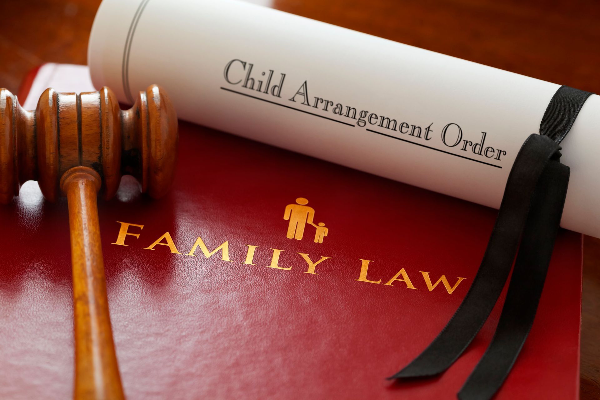 Family lawyer tools on table including gavel, law books, and custody paperwork in family court case.