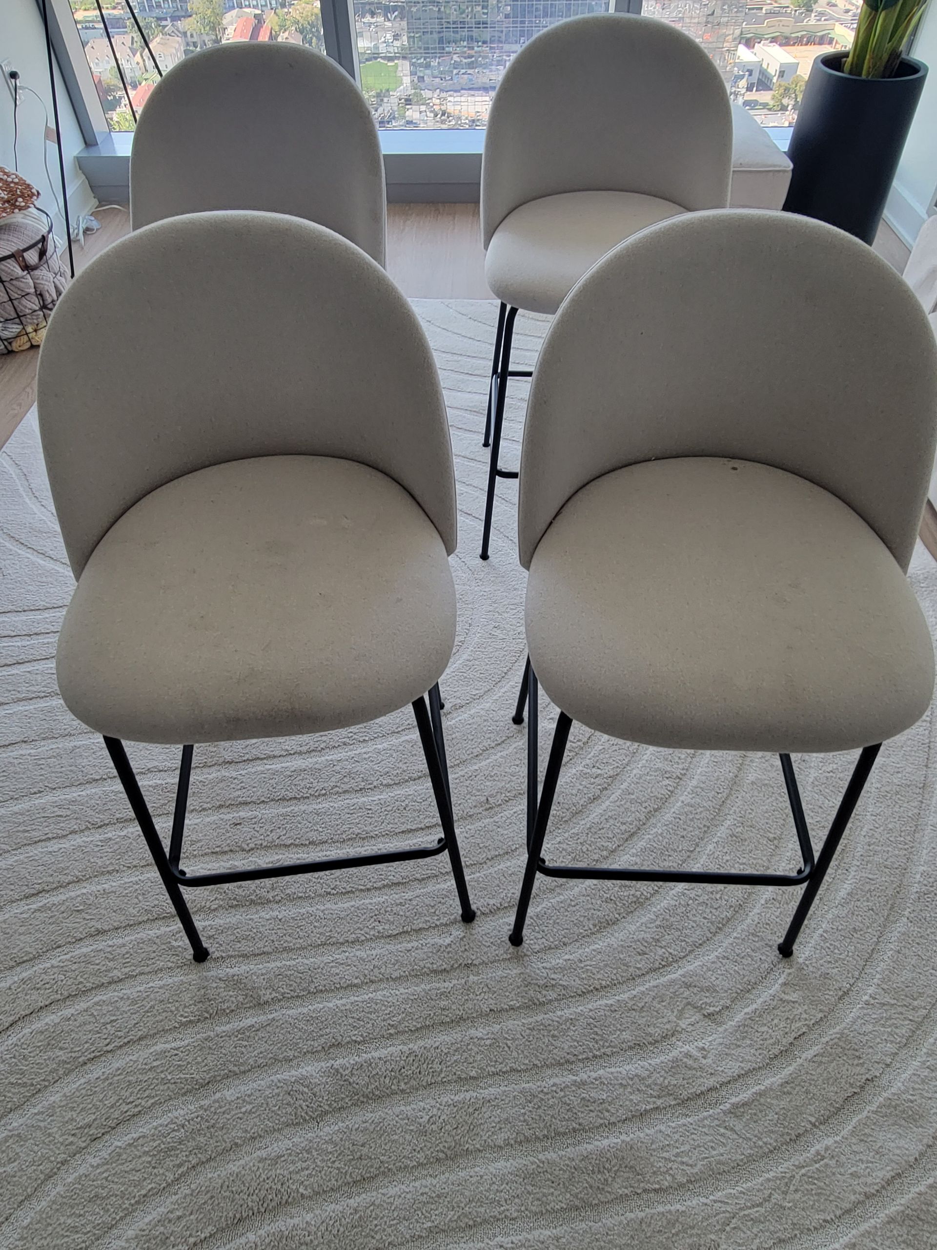 Four chairs are sitting on a rug in a living room.